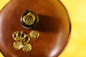 Overhead shot of gold coins on a brown surface against a yellow background.