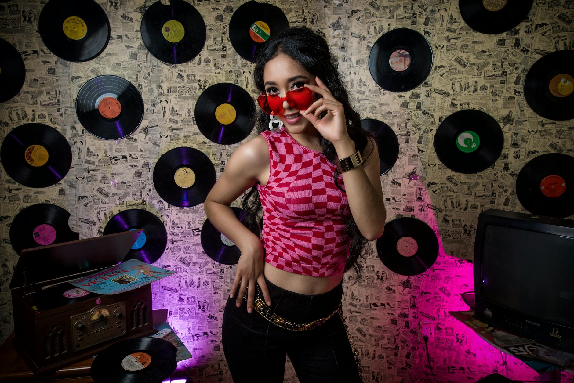 Stylish woman posing in a retro-themed club with vinyl records and vibrant lighting.