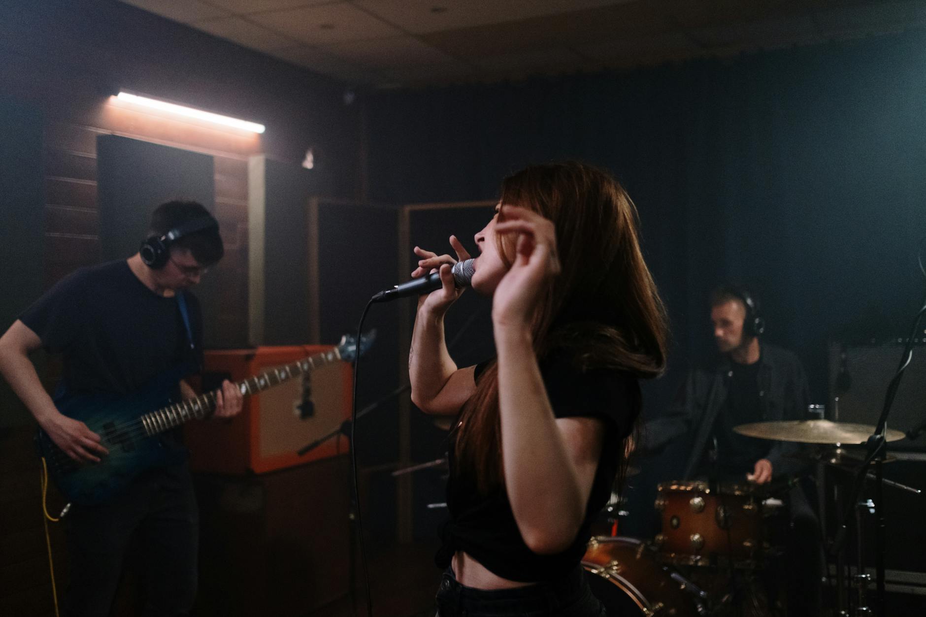 A dynamic music band performing energetically in a rehearsal studio.