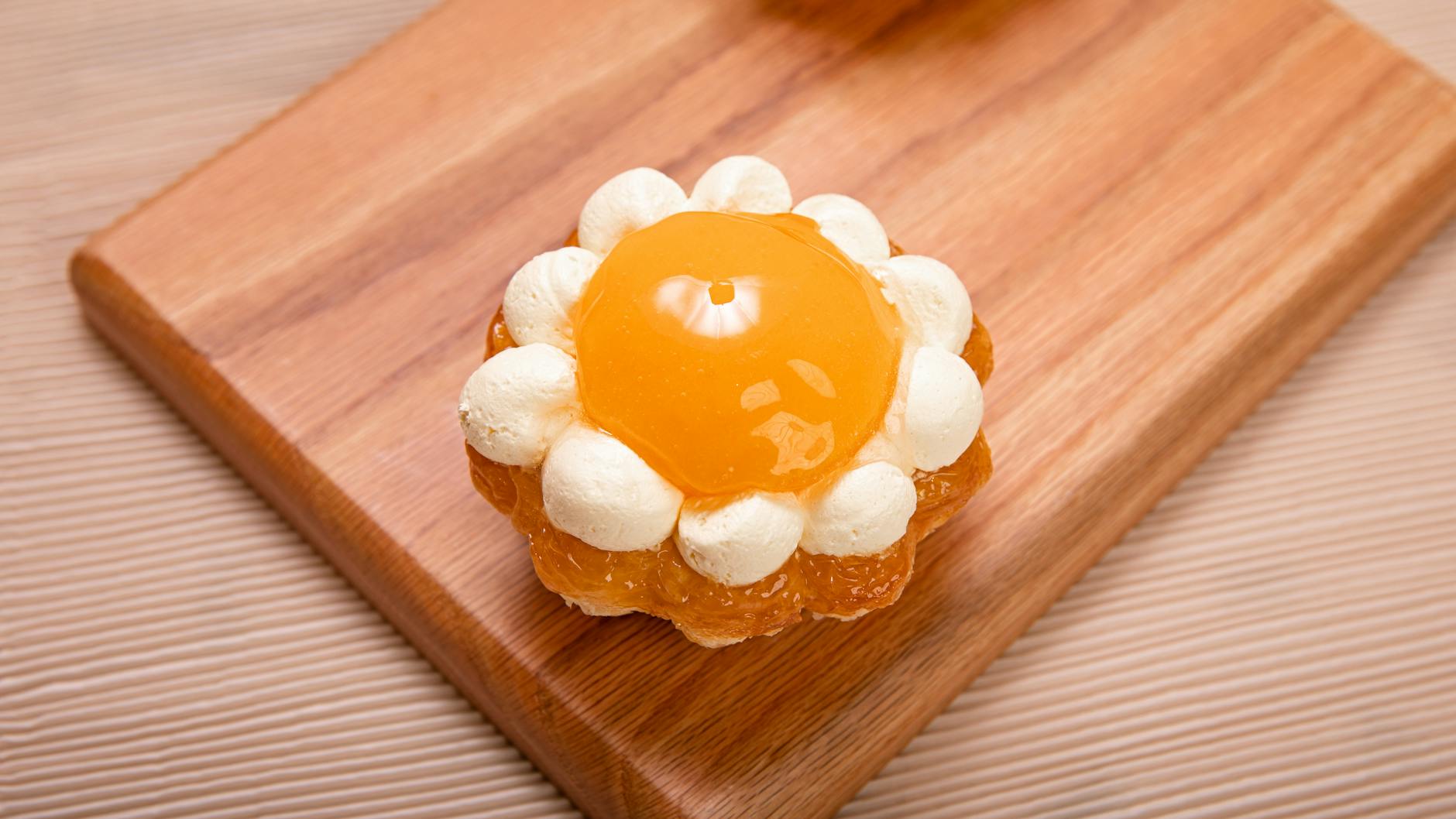 Close-up of a delectable apricot tart on a wooden board, perfect for dessert lovers.