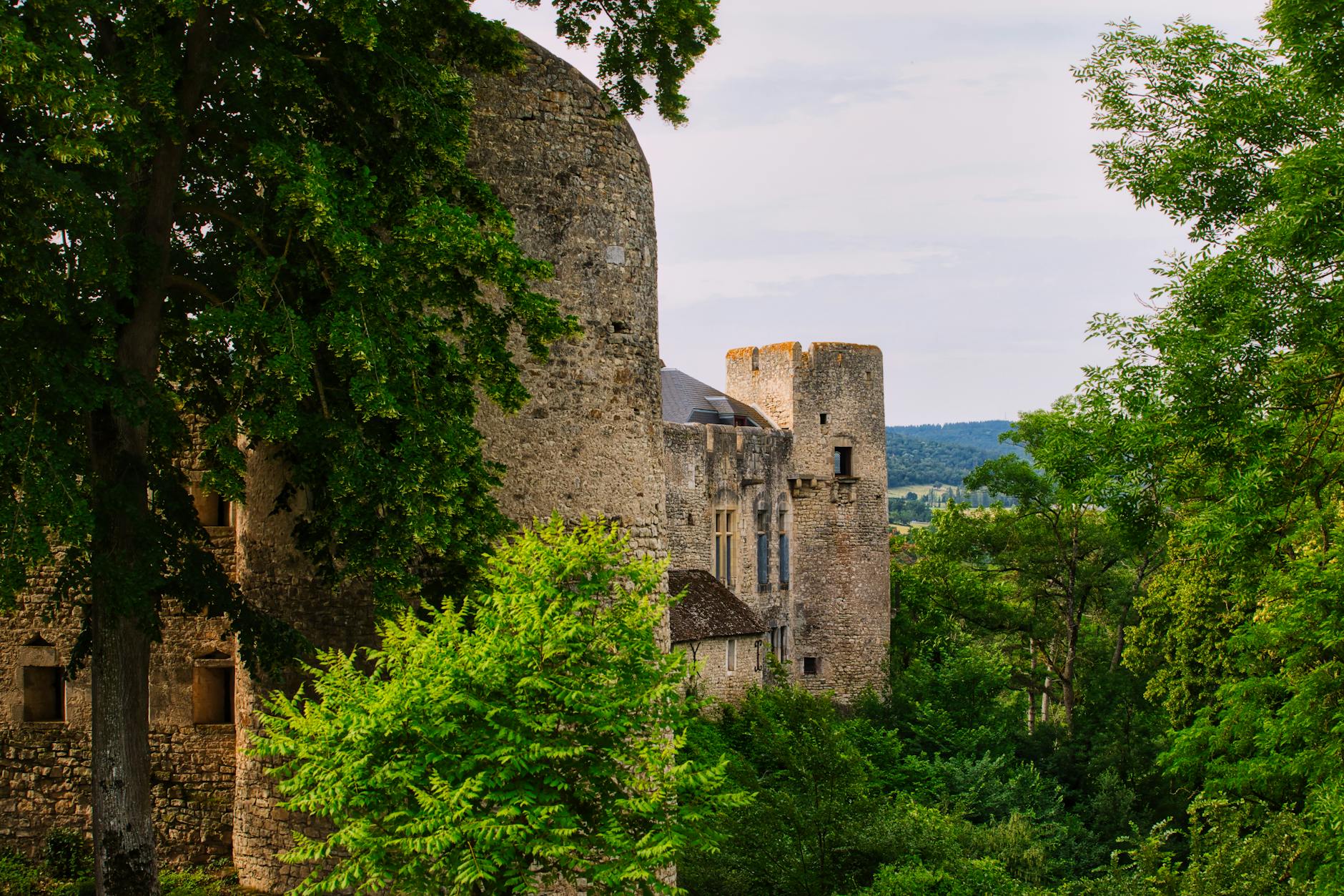 Enchanting medieval castle amidst vibrant greenery in Francescas, a serene summer day.