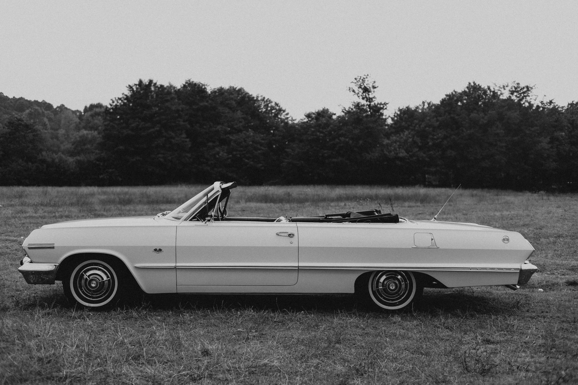 Classic Chevrolet Impala convertible in black and white, set in a serene field in Istanbul.