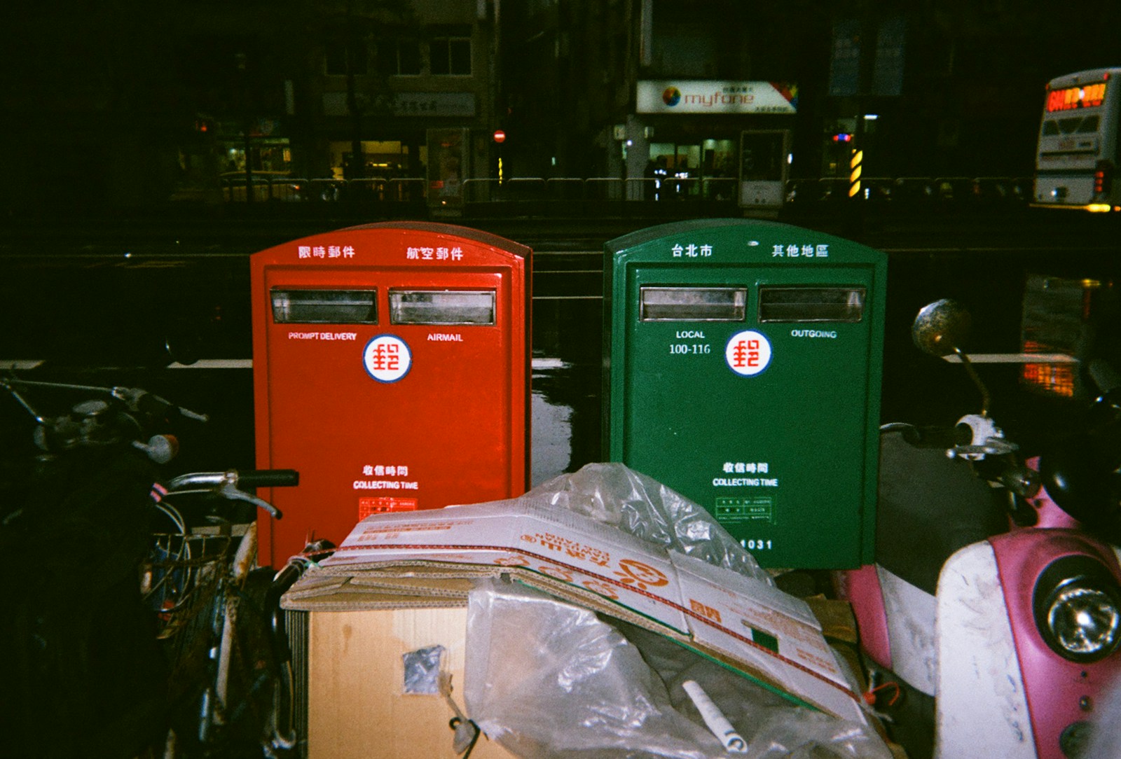 two green and red boxes standing near two motorcycles